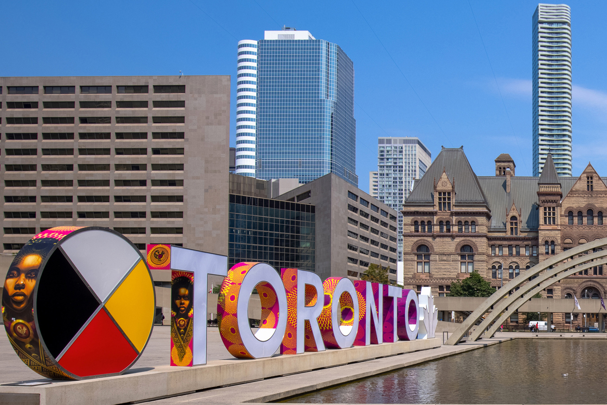 image of a a Toronto sign in downtown Toronto with the sign in the foreground and buildings in the background