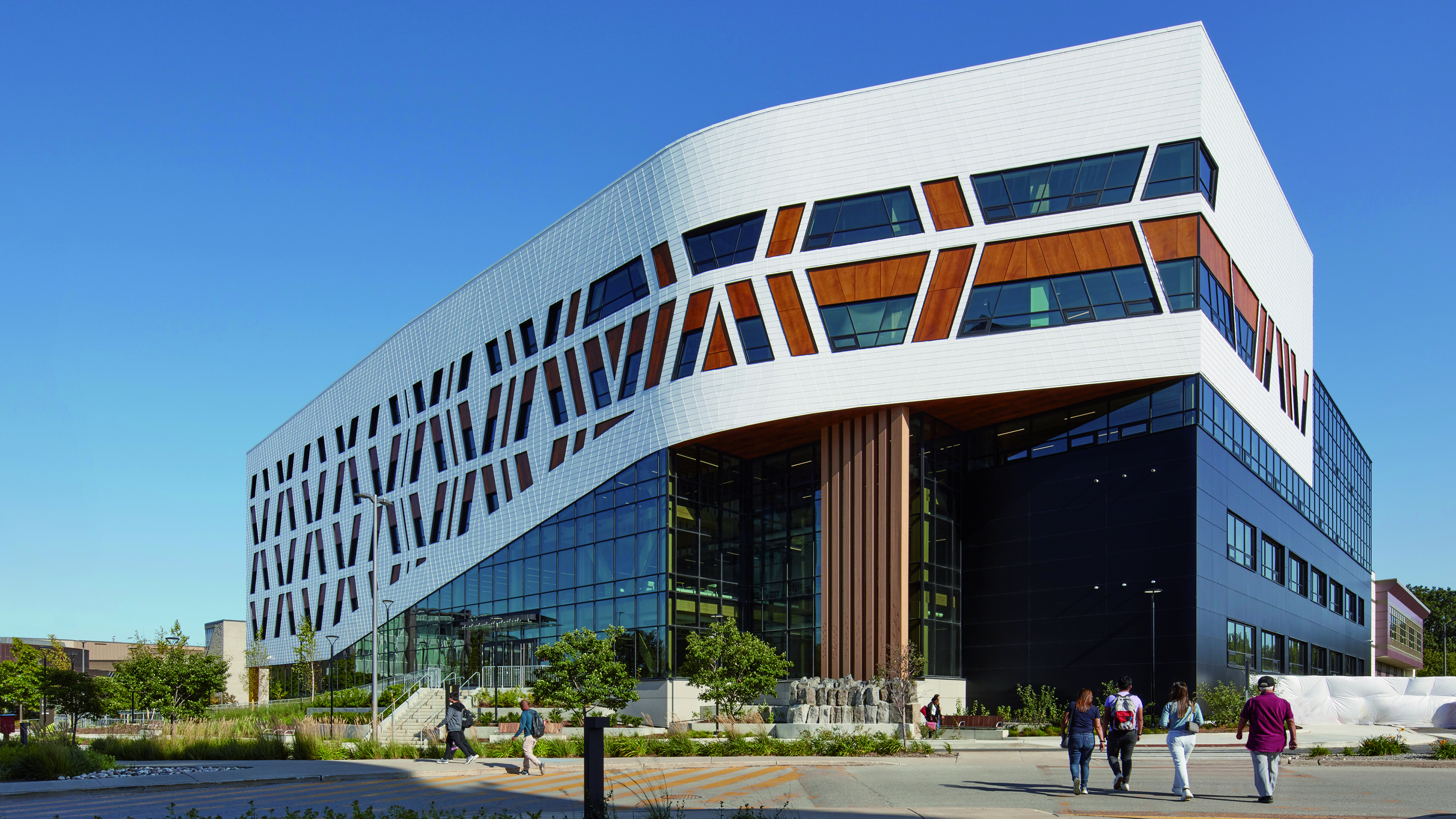 Exterior view of the Centennial College with four users approaching the building entrance